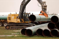 An Enbridge worker loads pipe just west of Morden, Man., on Thursday, Aug. 16, 2018.